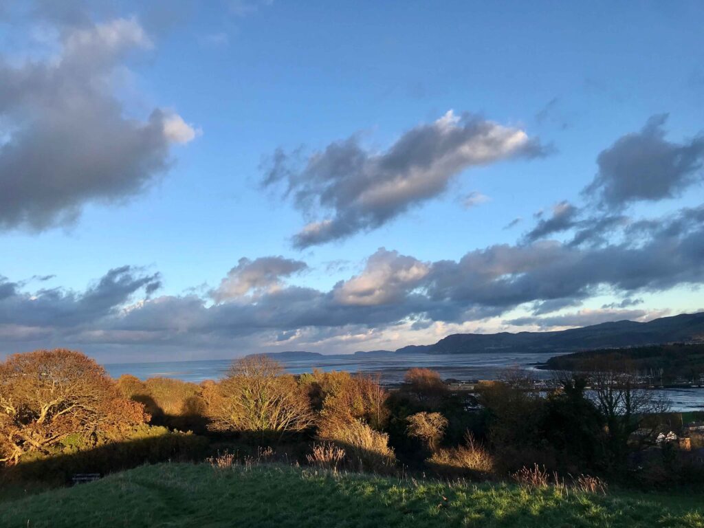 View from a hilltop in Bangor, Wales. The Irish Sea and the Eryri Mountains visible in the background.